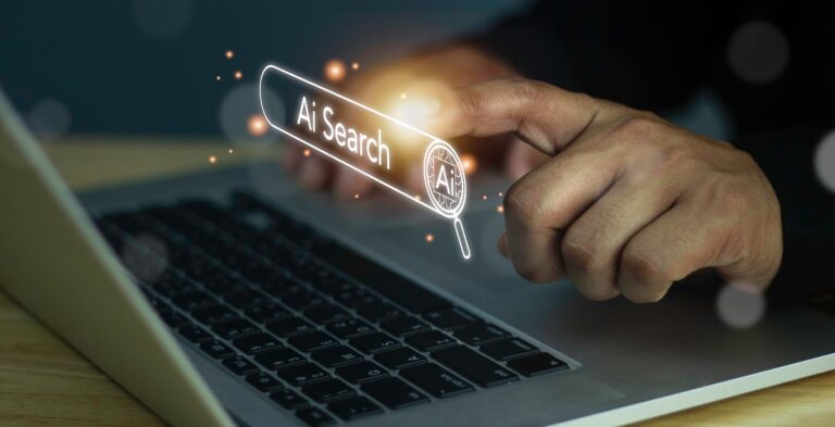 Hand tapping an AI search bar on a laptop, representing Google's new AI search guide for businesses